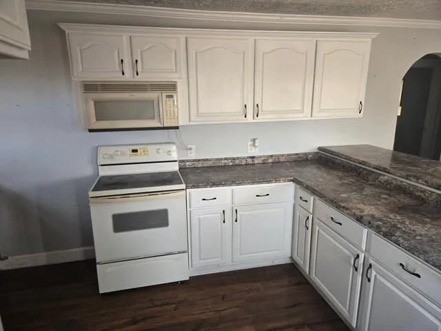 a kitchen with white cabinets stainless steel appliances and sink