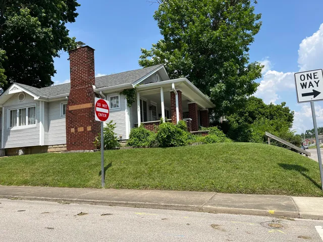 a front view of a house with a garden and yard