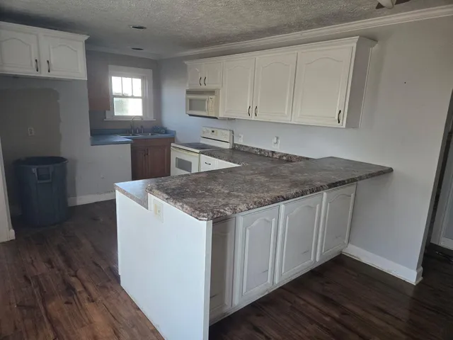 a kitchen with cabinets appliances and wooden floor