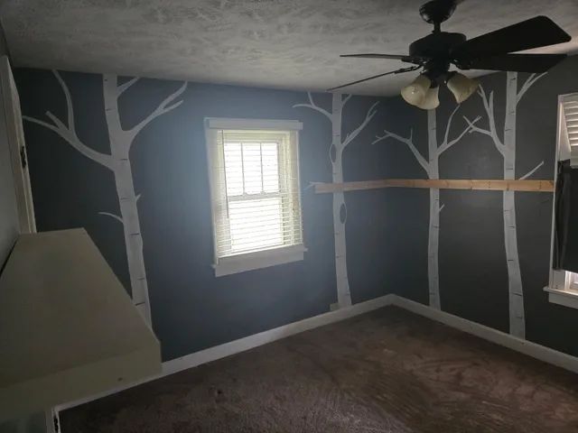 a view of a room with a ceiling fan and a window