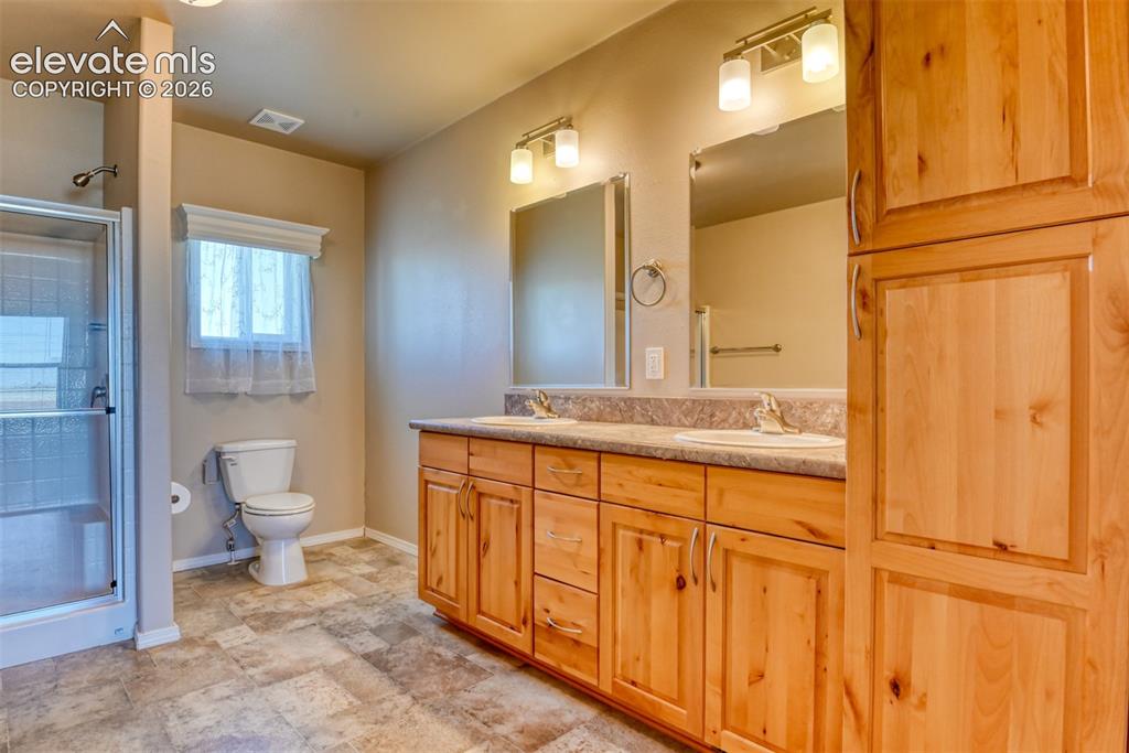 22558 Enoch Road Calhan, CO 80808 - Photo 14 of 50 a bathroom with a granite countertop sink toilet and shower