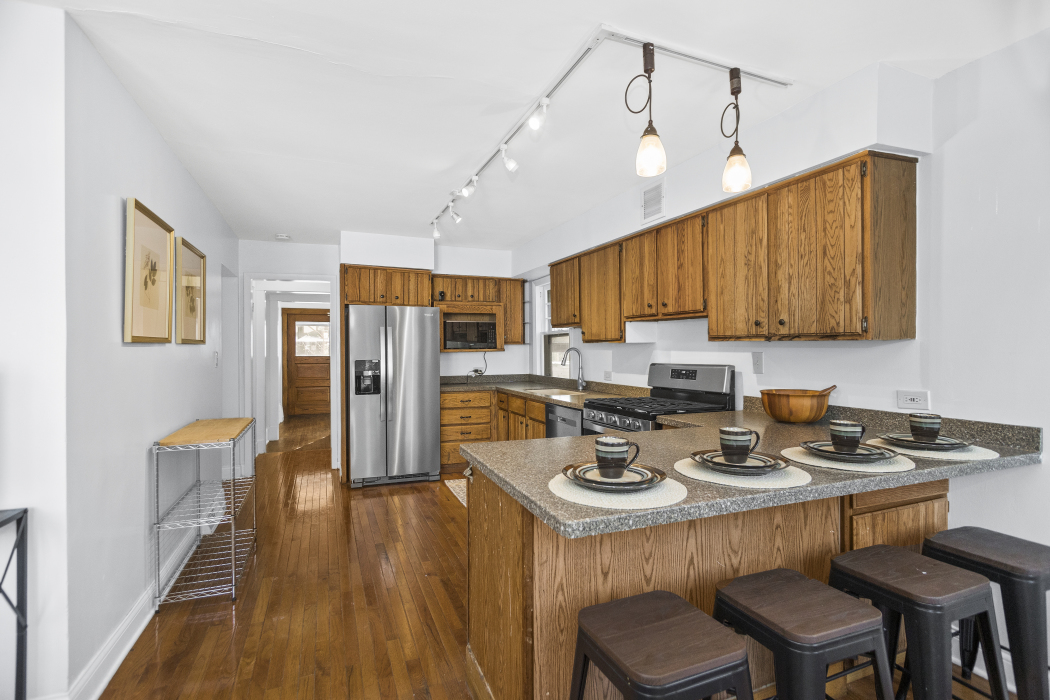 Undisclosed Address Evanston, IL 60201 - Photo 16 of 39 a kitchen with stainless steel appliances granite countertop a stove refrigerator a sink dishwasher and wooden cabinets with wooden floor