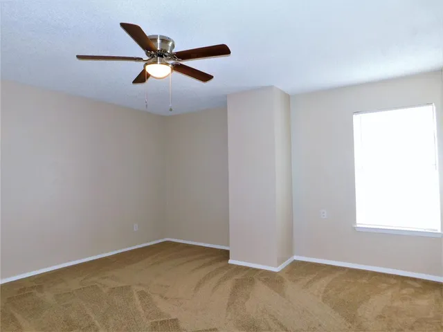 an empty room with closet and windows