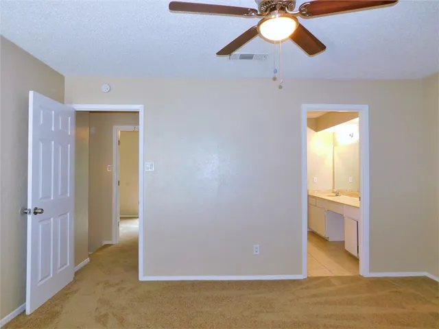 a view of a livingroom with a chandelier fan and a window