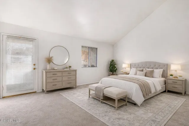 a spacious bedroom with a bed a mirror and dresser