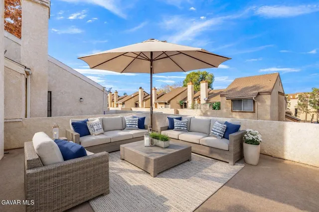 a view of a patio with couches and a umbrella