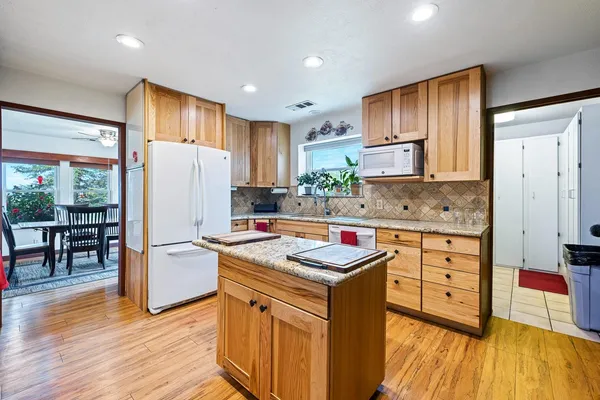 a kitchen that has a lot of cabinets in it and wooden floors