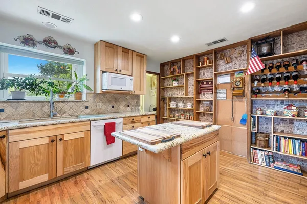 a open kitchen with stainless steel appliances granite countertop a stove and a refrigerator