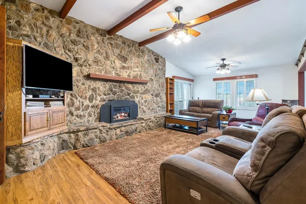 a living room with furniture a flat screen tv and a fireplace
