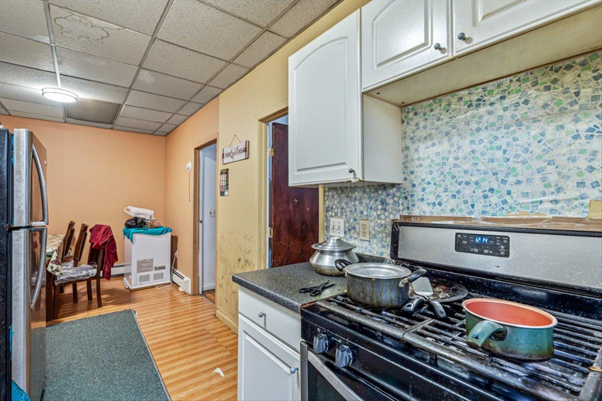 1715 St Peters Avenue Bronx, NY 10461 - Photo 16 of 30 a kitchen with stainless steel appliances granite countertop a stove and cabinets