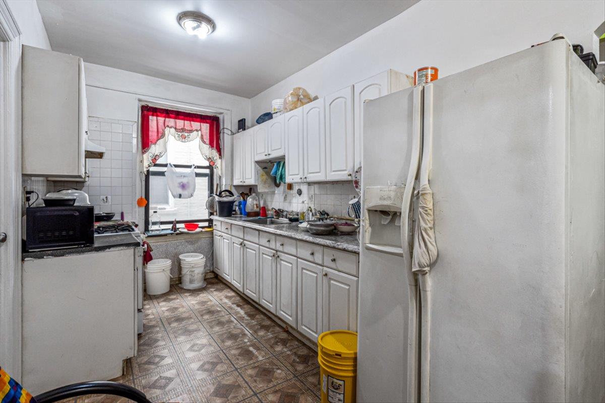 1715 St Peters Avenue Bronx, NY 10461 - Photo 24 of 30 a kitchen with a refrigerator and a stove top oven