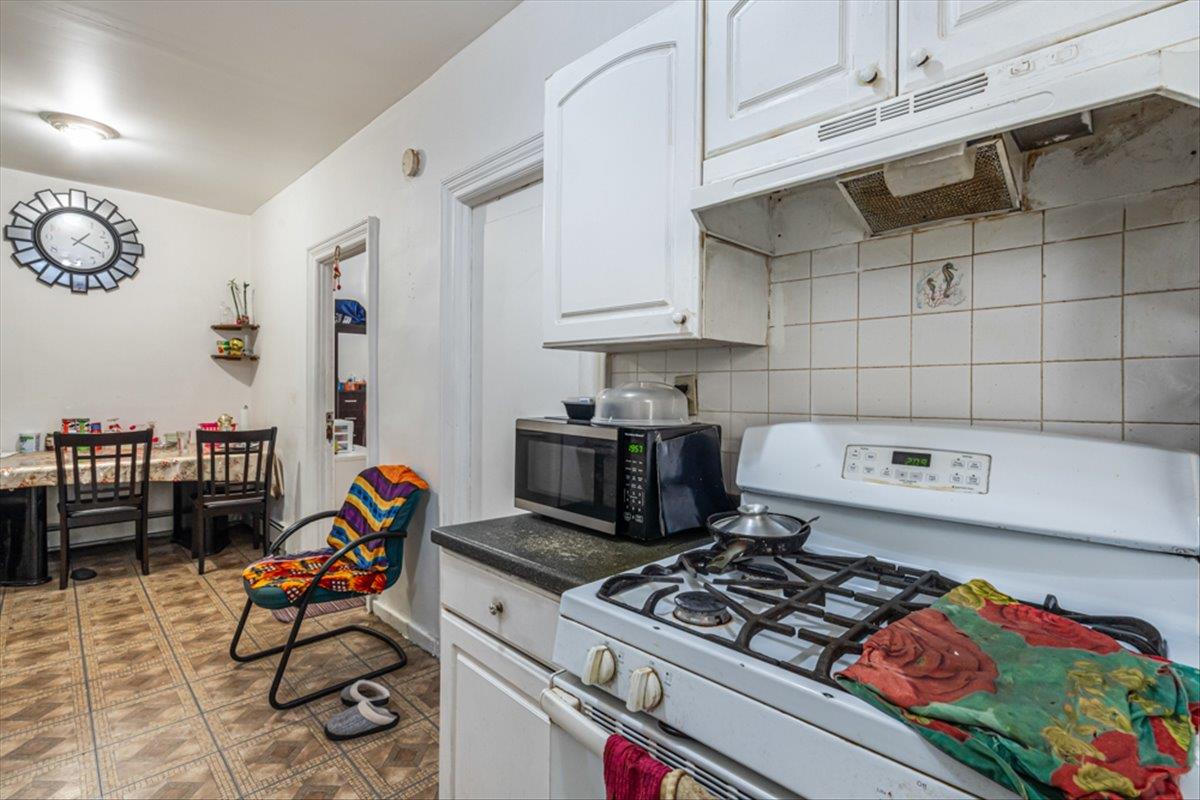 1715 St Peters Avenue Bronx, NY 10461 - Photo 25 of 30 a kitchen with a stove and a wooden floor