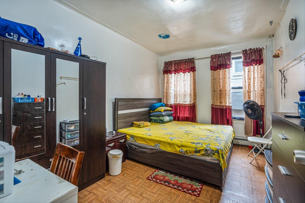 1715 St Peters Avenue Bronx, NY 10461 - Photo 26 of 30 a bedroom with a bed a dresser and a large window
