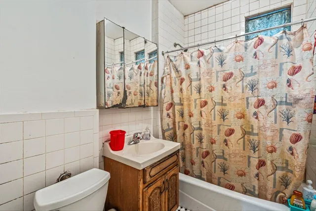 a bathroom with a sink toilet and shower curtain