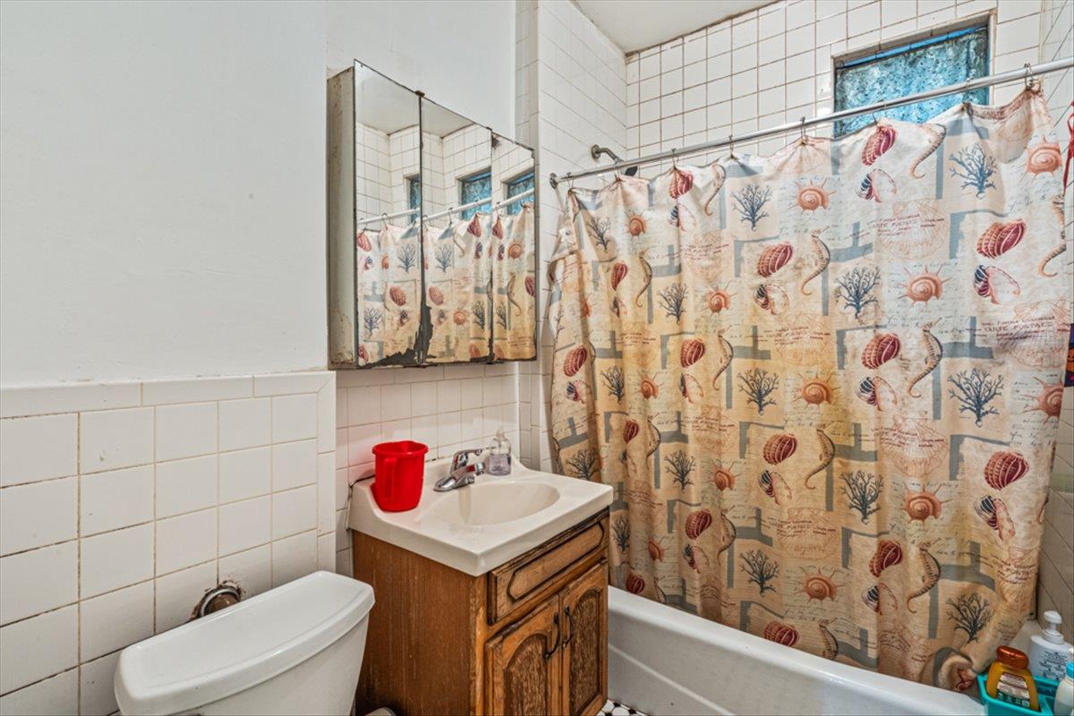 1715 St Peters Avenue Bronx, NY 10461 - Photo 27 of 30 a bathroom with a sink toilet and shower curtain