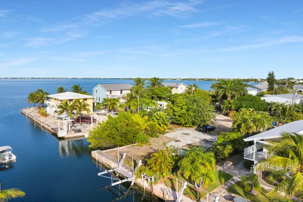 an aerial view of a house with a yard and lake view