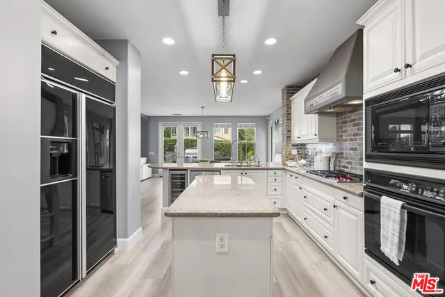 a kitchen with granite countertop white cabinets and stainless steel appliances