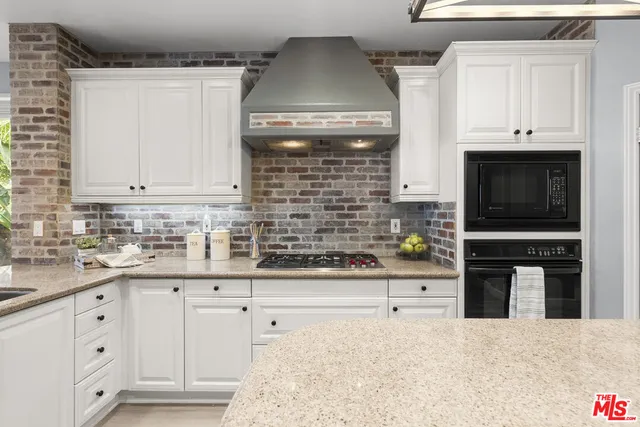 a kitchen with stainless steel appliances a sink a counter top space cabinets and stainless steel appliances