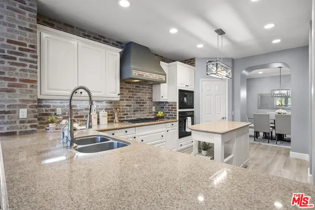 a kitchen with stainless steel appliances kitchen island granite countertop a sink and cabinets