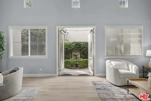 a view of a hallway with wooden floor and windows