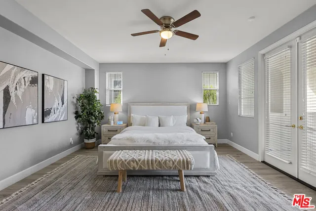 a spacious bedroom with a bed and wooden floor
