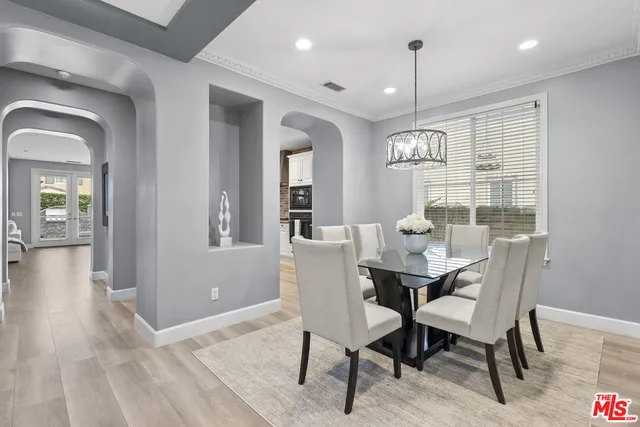 a dining room with furniture a chandelier and wooden floor