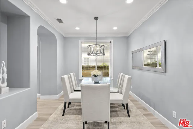 a view of a dining room with furniture a chandelier and wooden floor