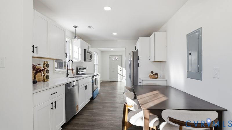 331 Walnut Street Petersburg, VA 23803 - Photo 9 of 34 a large white kitchen with stainless steel appliances kitchen island granite countertop a dining table chairs and a refrigerator