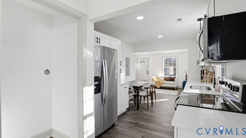 331 Walnut Street Petersburg, VA 23803 - Photo 10 of 34 a living room with stainless steel appliances furniture a flat screen tv and a refrigerator