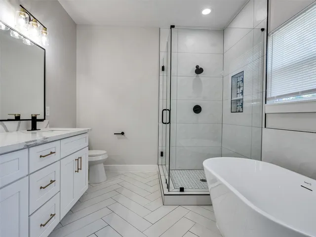a bathroom with a double vanity sink toilet and shower