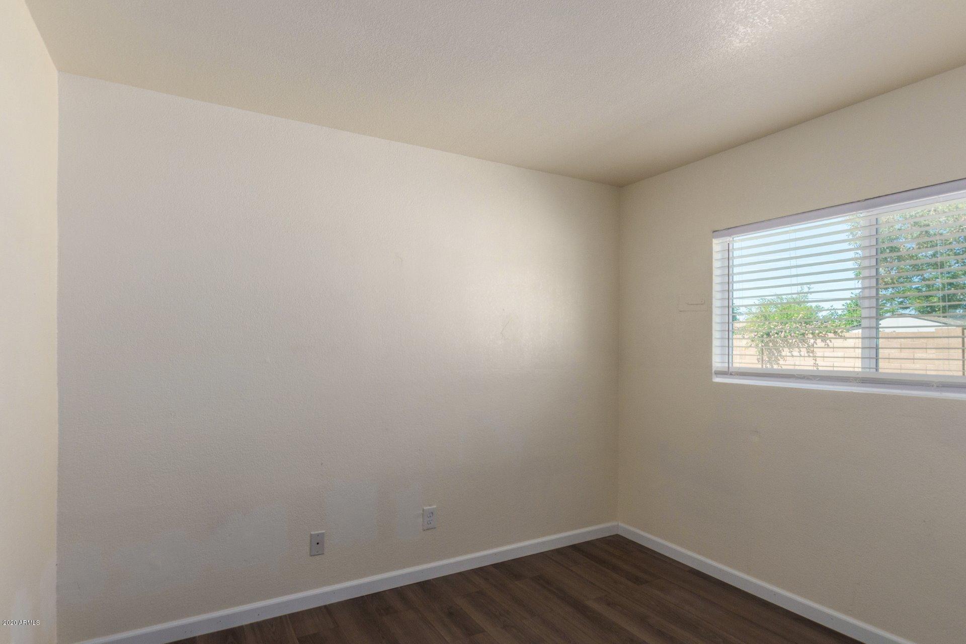 1837 West Vineyard Road Phoenix, AZ 85041 - Photo 20 of 30 an empty room with wooden floor and windows