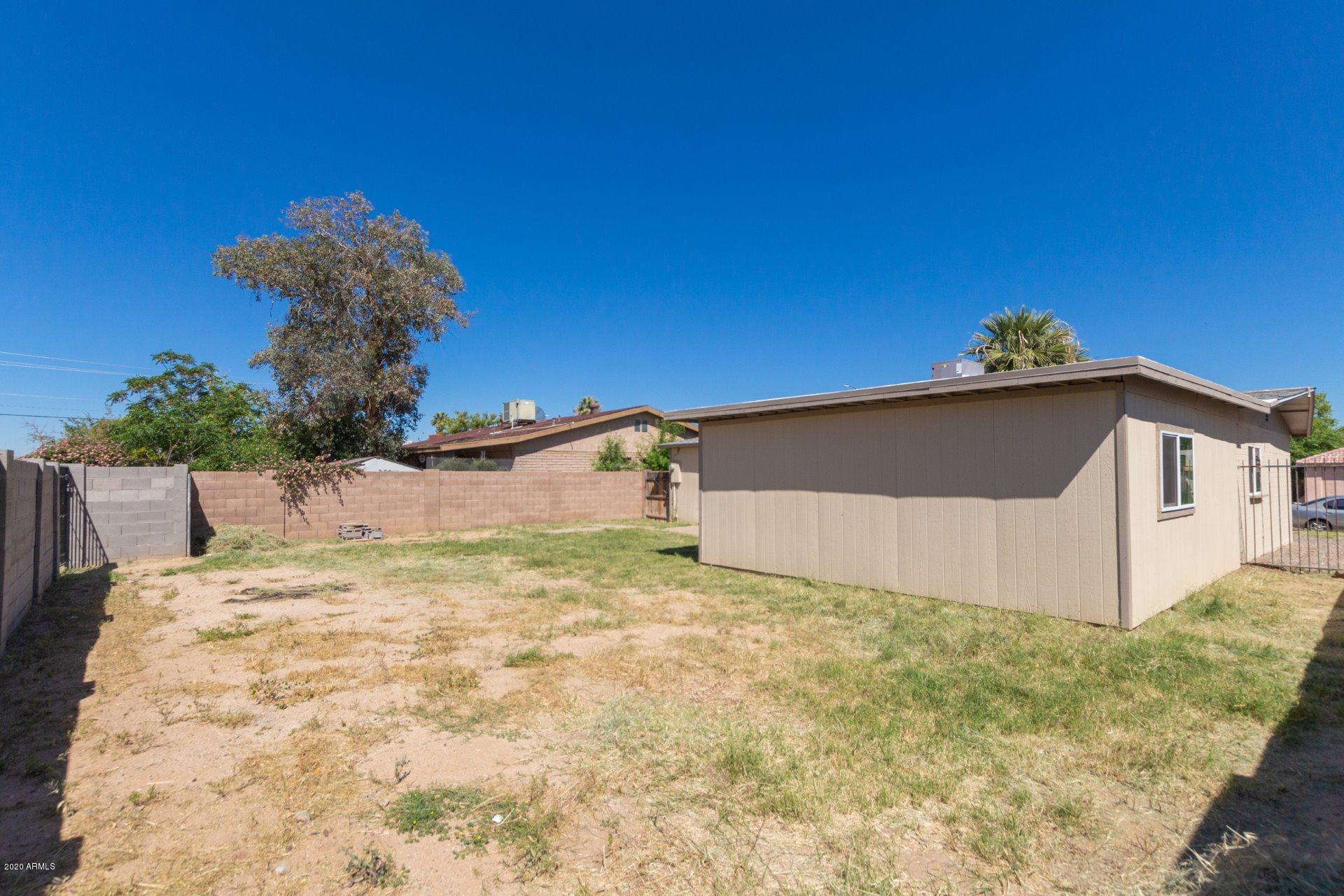 1837 West Vineyard Road Phoenix, AZ 85041 - Photo 26 of 30 a yellow house with a yard