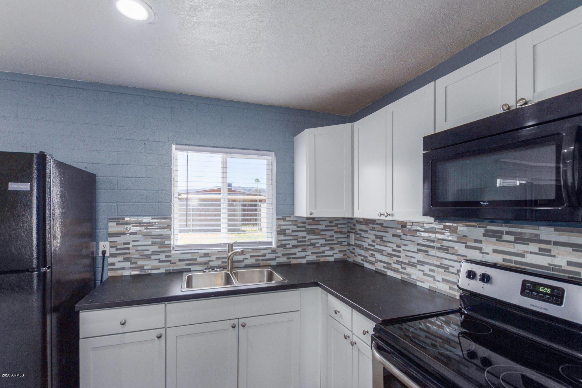 1837 West Vineyard Road Phoenix, AZ 85041 - Photo 9 of 30 a kitchen with stainless steel appliances a stove sink and microwave