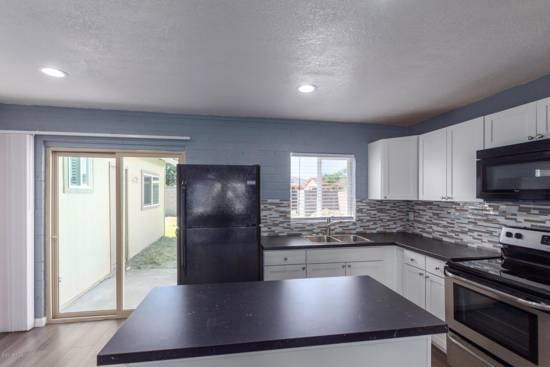 1837 West Vineyard Road Phoenix, AZ 85041 - Photo 10 of 30 a kitchen with granite countertop a refrigerator and a sink