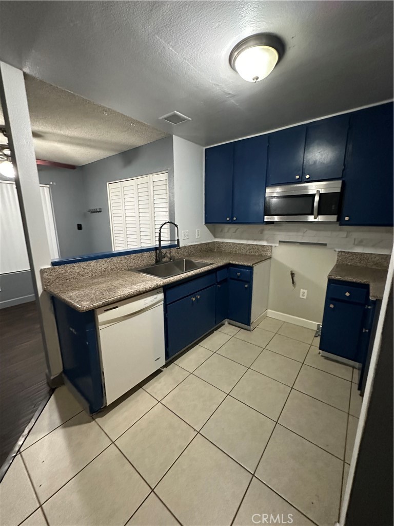 165 Racquet Club Drive Compton, CA 90220 - Photo 14 of 47 a kitchen with stainless steel appliances granite countertop a sink and a stove