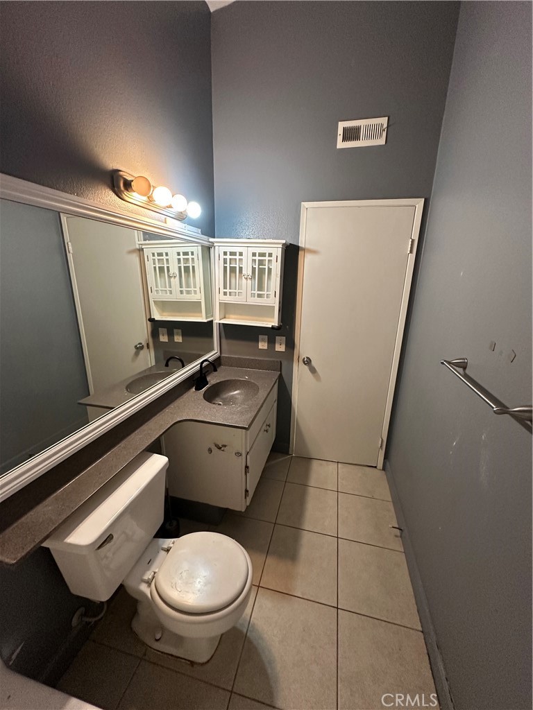 165 Racquet Club Drive Compton, CA 90220 - Photo 35 of 47 a bathroom with a toilet a sink and mirror