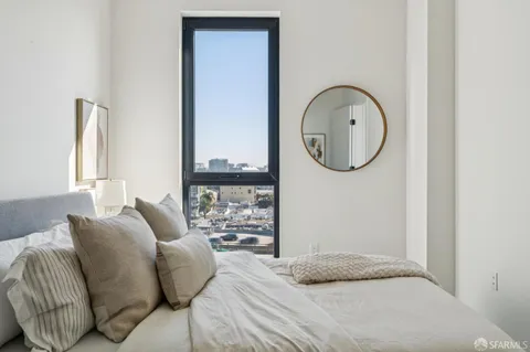 a bedroom with a bed a mirror and a window