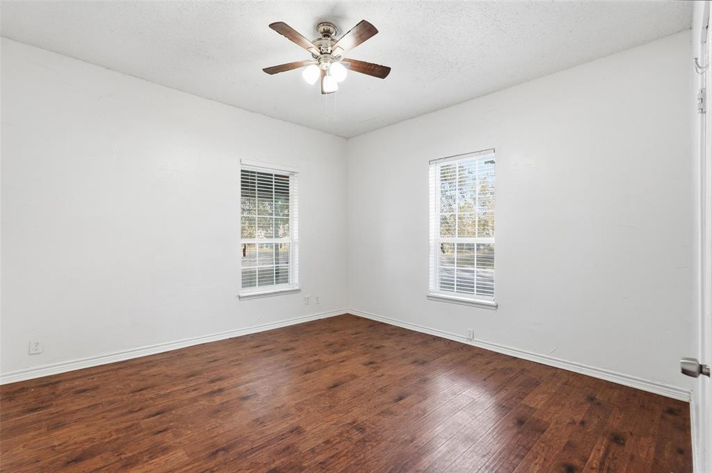 900 West Morgan Street Denison, TX 75020 - Photo 11 of 40 a view of an empty room with a window and wooden floor