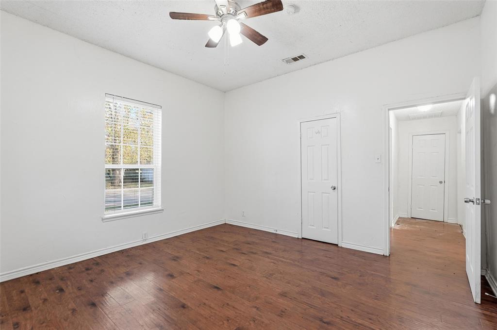 900 West Morgan Street Denison, TX 75020 - Photo 12 of 40 a view of an empty room with a window and wooden floor