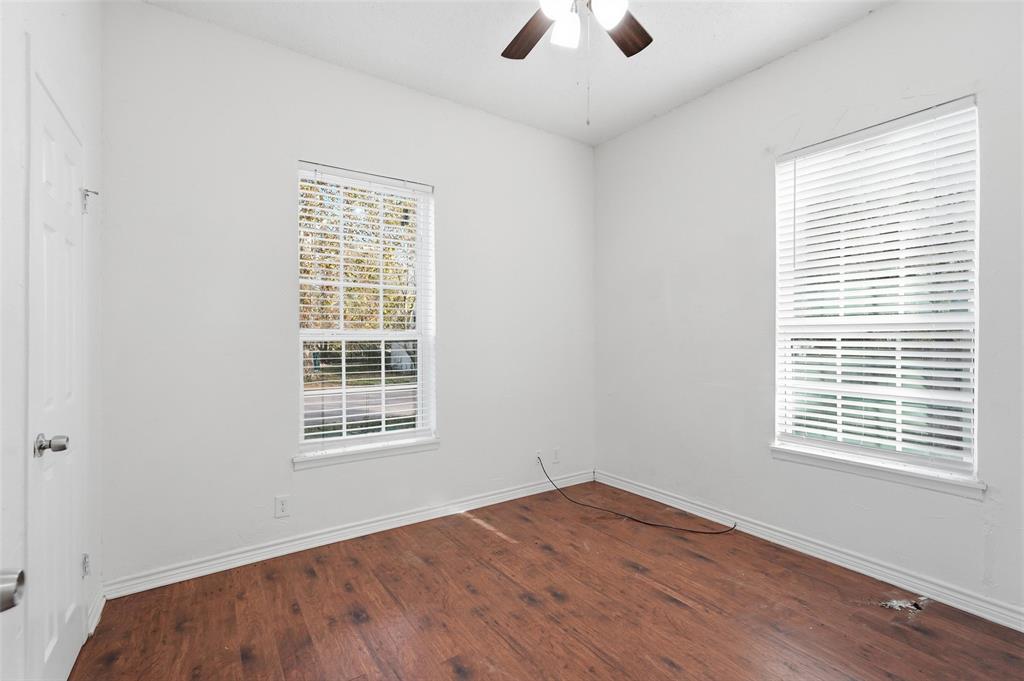 900 West Morgan Street Denison, TX 75020 - Photo 16 of 40 a view of an empty room with wooden floor and a window