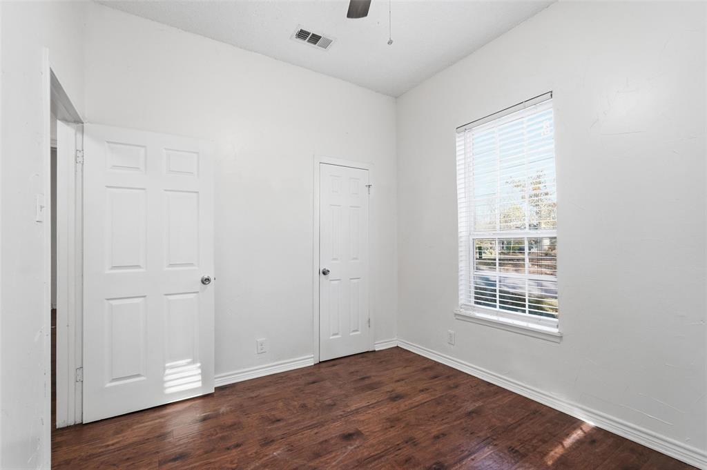 900 West Morgan Street Denison, TX 75020 - Photo 17 of 40 a view of an empty room with wooden floor and a window