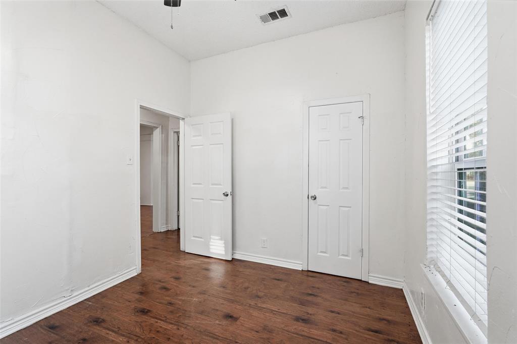 900 West Morgan Street Denison, TX 75020 - Photo 18 of 40 a view of an empty room with wooden floor and a window