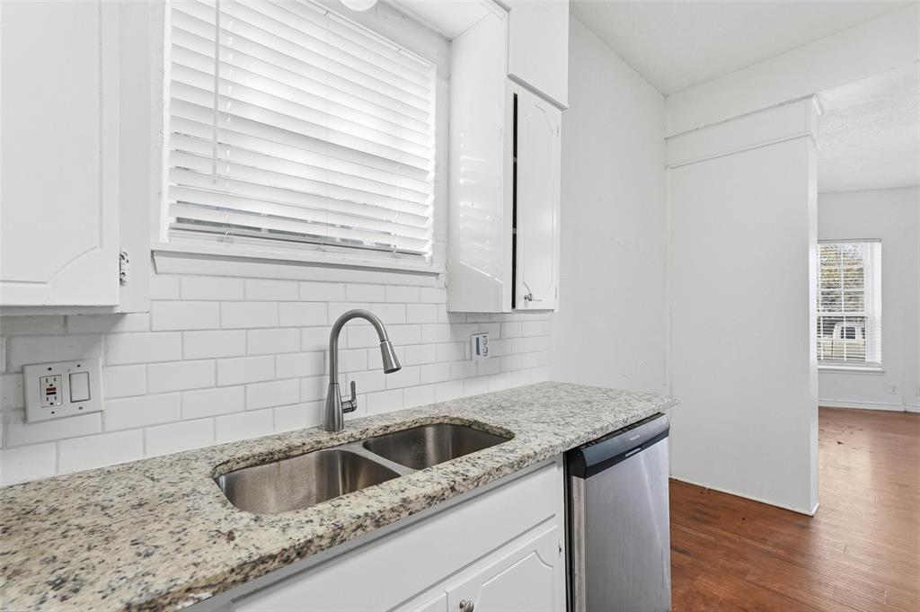 900 West Morgan Street Denison, TX 75020 - Photo 6 of 40 a kitchen with stainless steel appliances granite countertop a sink a window and wooden floor