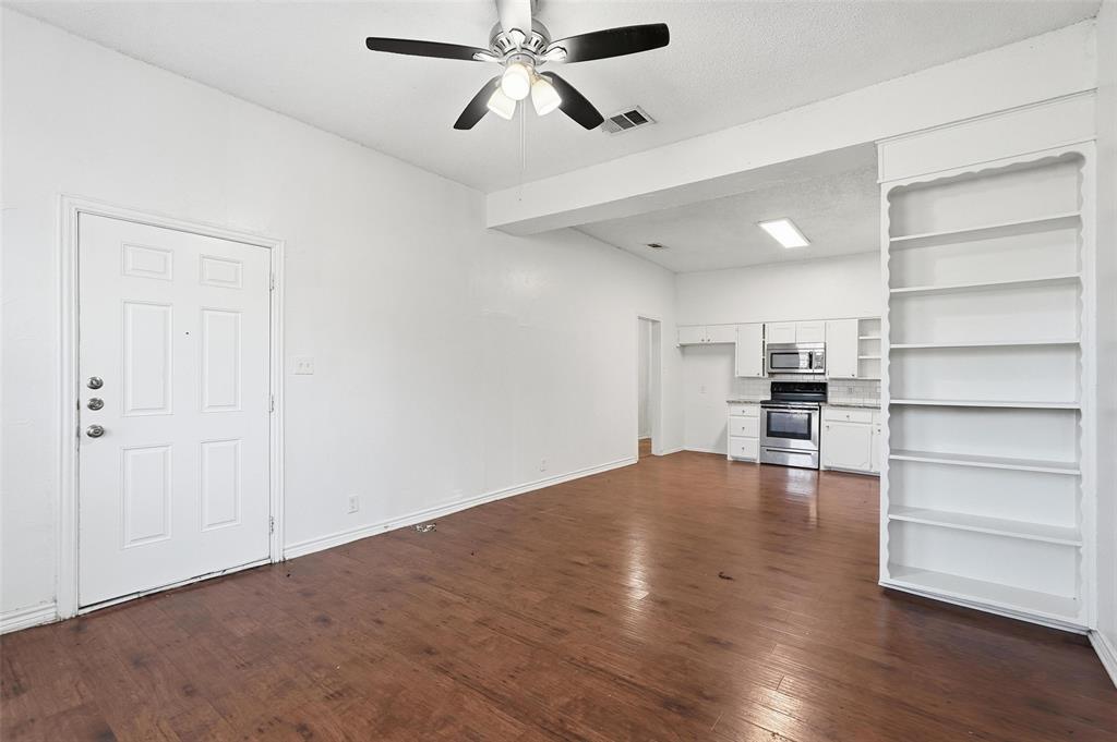 900 West Morgan Street Denison, TX 75020 - Photo 7 of 40 a view of empty room with wooden floor and window