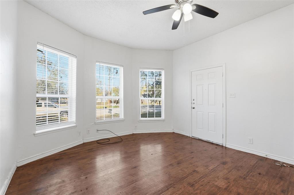900 West Morgan Street Denison, TX 75020 - Photo 10 of 40 wooden floor in an empty room with a window