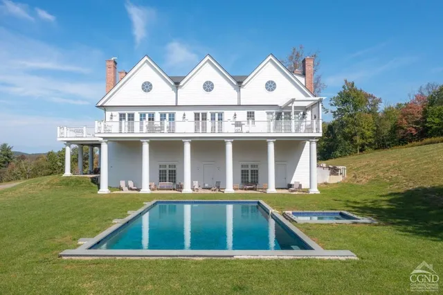 a living room with couches and painting on the wall with wooden floor