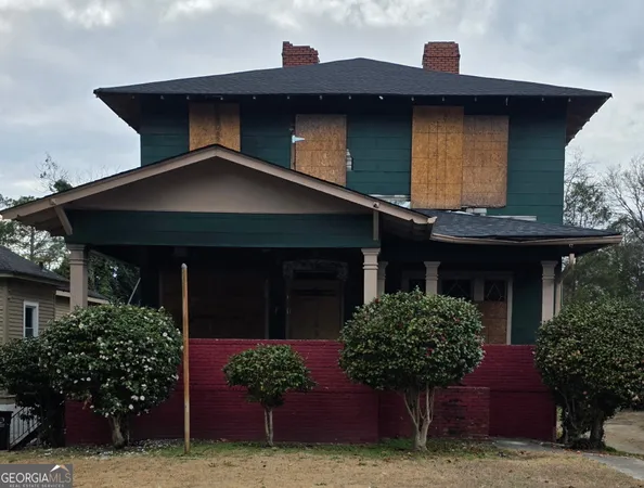 a house with potted plants in front of it