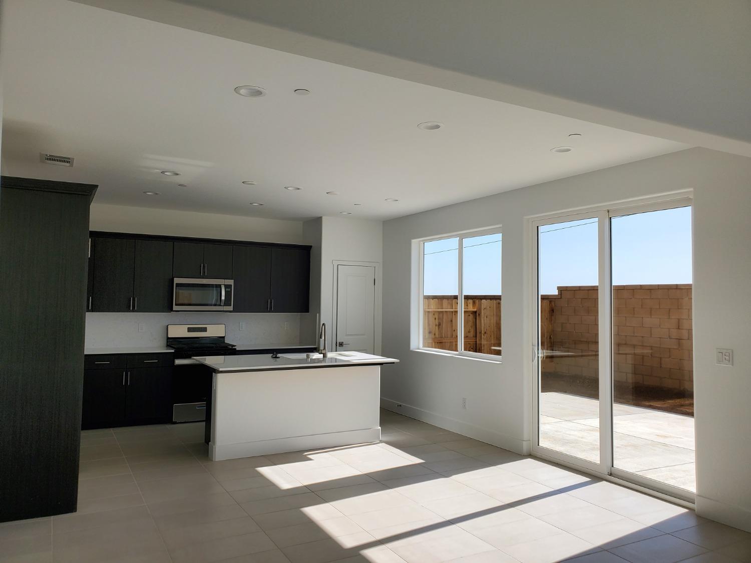 496 Talus Way South Madera, CA 93636 - Photo 3 of 9 a kitchen with stainless steel appliances a sink and a refrigerator
