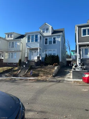a front view of a building with lot of cars parked on road