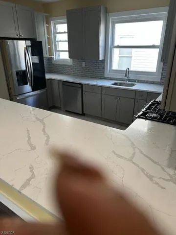 a kitchen with stainless steel appliances a sink window and a refrigerator